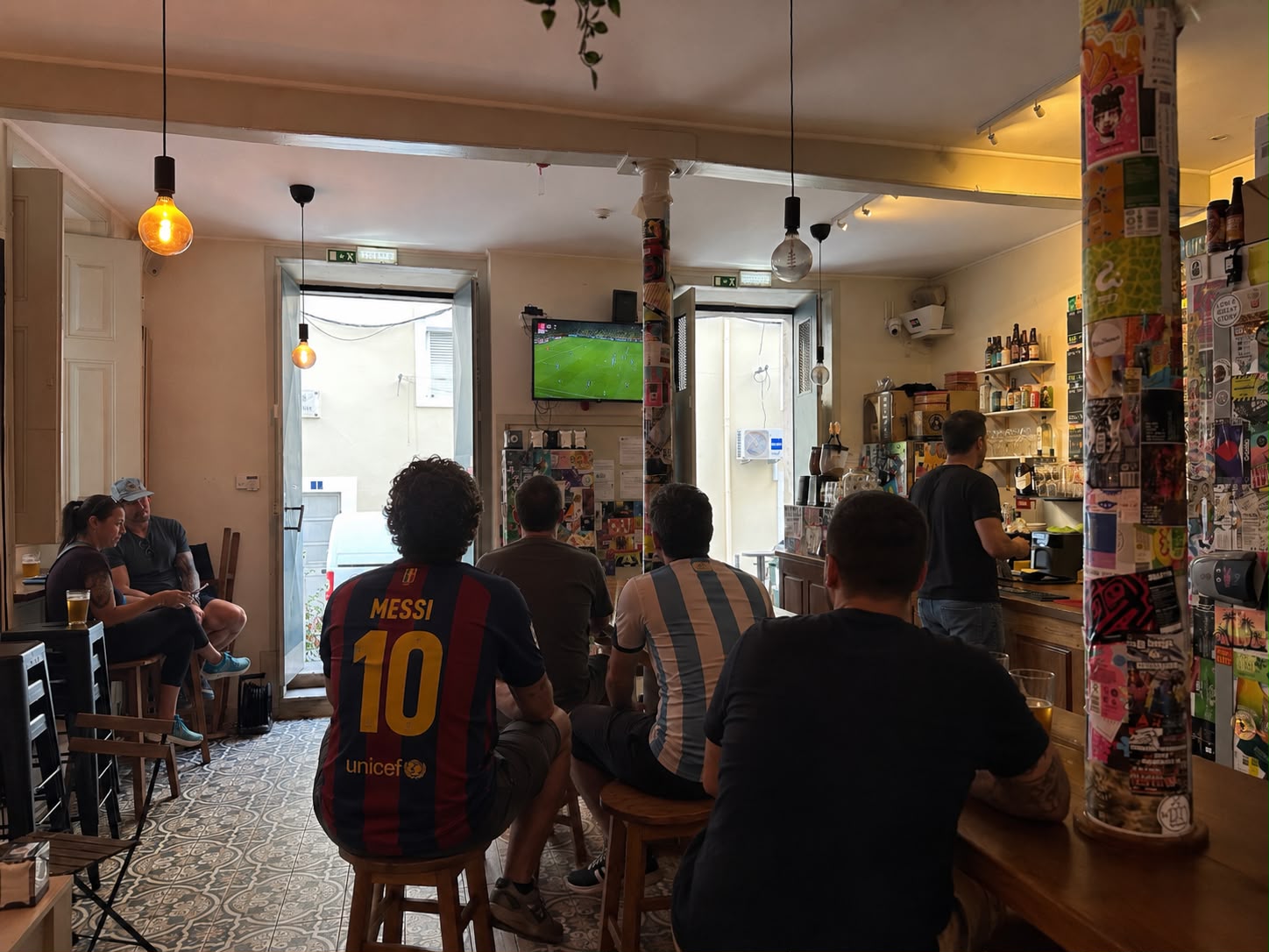 Football fans watching a match with craft beer at Queen Ale sports bar in Lisbon